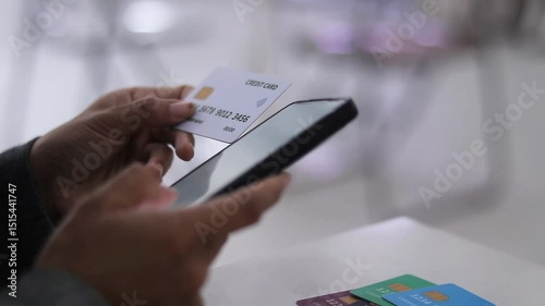 A person uses a smartphone to make a purchase with a credit card. Convenient contactless payments and secure financial transactions concept. 