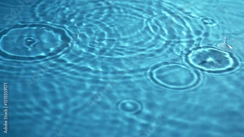 Water drops scattered on a clean blue surface with ripple effects