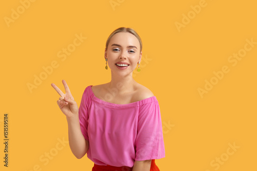 Happy young woman showing v...
