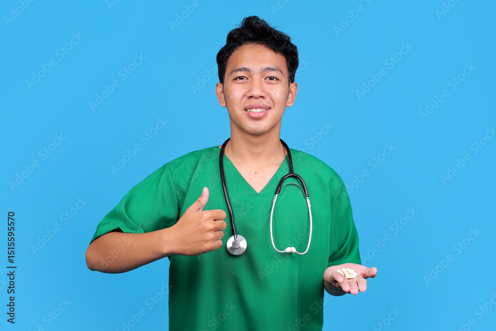 Nurse in Green Scrubs Hold Pills Tablet and Showing Thumb Up on Blue Background Nurse in Green Scrubs Hold Pills Tablet and Showing Thumb Up on Blue Background