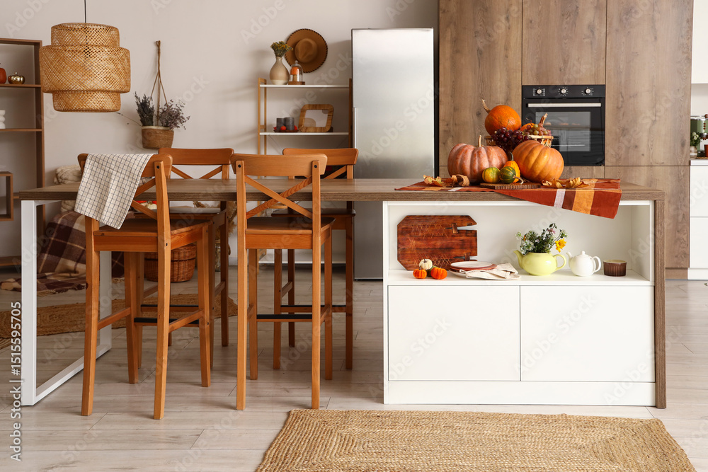 Interior of modern kitchen with wooden furniture and pumpkins Interior of modern kitchen with wooden furniture and pumpkins
