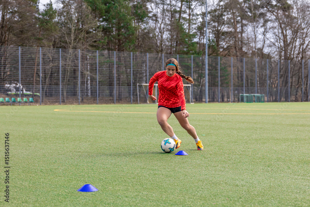 Obraz premium Girl on the soccer field. Soccer training. Active lifestyle. Football concept.