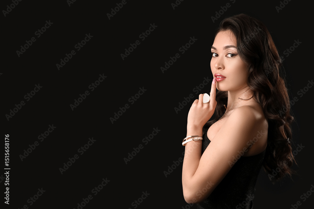 Beautiful young Asian woman with stylish jewelry on dark background Beautiful young Asian woman with stylish jewelry on dark background