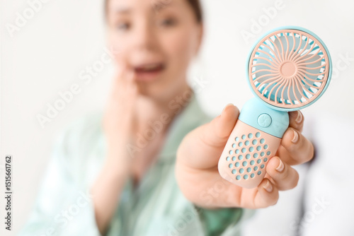 Young woman with mini fan i...