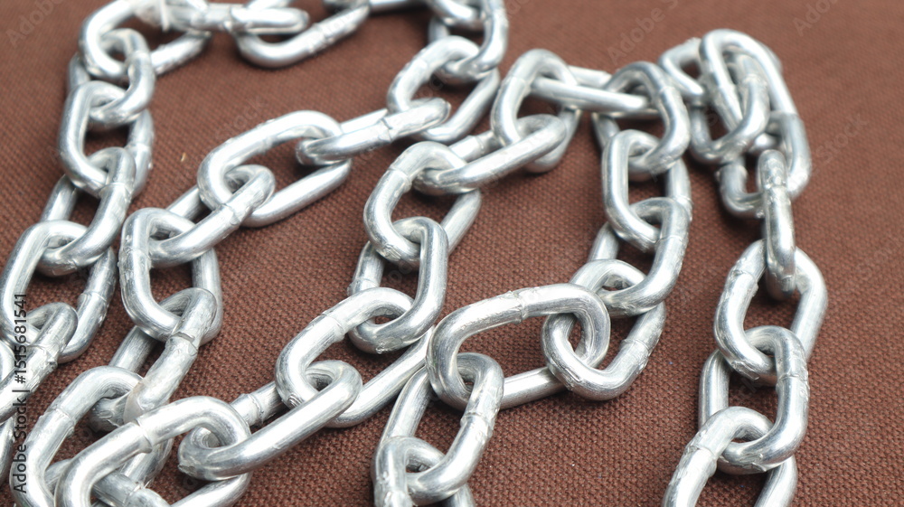 steel chain on brown background, steel chain links connected to each other steel chain on brown background, steel chain links connected to each other