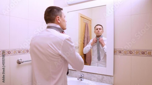 Elegant businessman getting ready in bathroom mirror