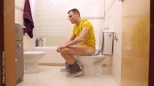 Man sitting on toilet finishing toilet paper roll and yelling