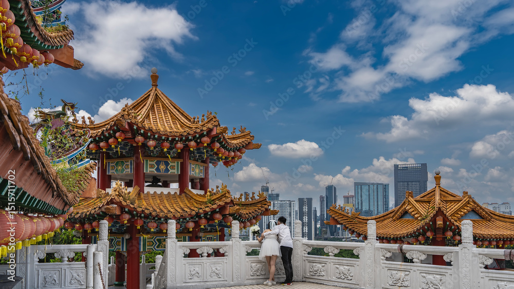 Tableau sur toile The bride and groom are hugging each other on the terrace of a Chinese temple, leaning on a stone carved railing