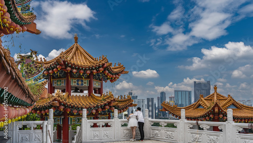 Photos The bride and groom are hugging each other on the terrace of a Chinese temple, leaning on a stone carved railing