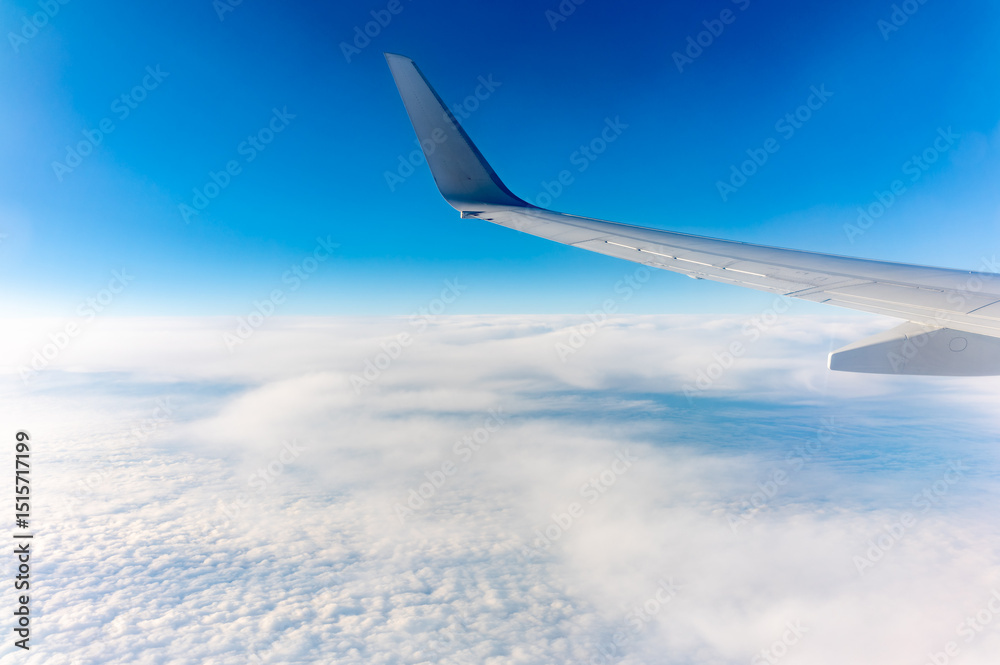 View from the airplane window at a beautiful cloudy sky and the airplane wing View from the airplane window at a beautiful cloudy sky and the airplane wing
