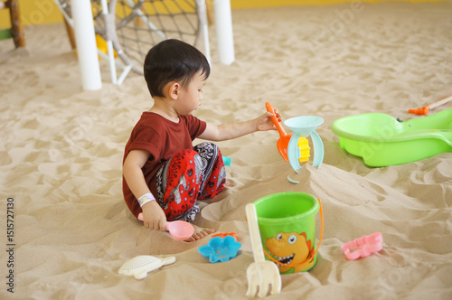Child Playing with Sand Toys: A young child engrossed in imaginative play with sand toys, creating and exploring in a beach-like setting.