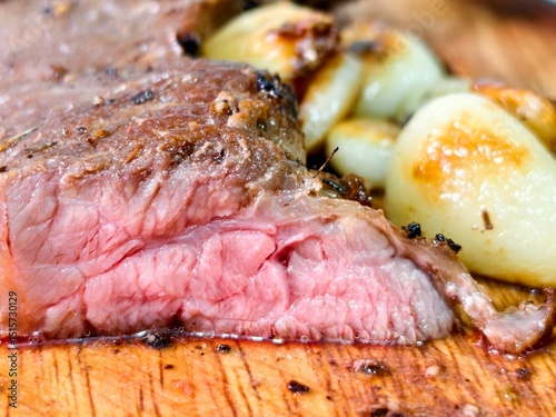 Juicy Medium Rare Steak Dish with Roasted Potatoes on Wooden Board