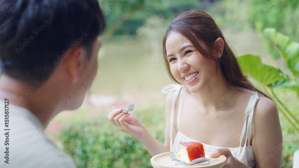 Fototapeta premium Asia people young adult man woman relax smile looking at camera take photo falling in love flirt at outdoor cafe enjoy fun date day. Joy happy asian lovers wife husband just married sweet newlywed