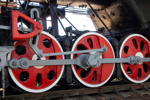Locomotive wheels in red color close-up.