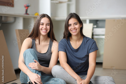 Happy roommates posing in a house under reformation