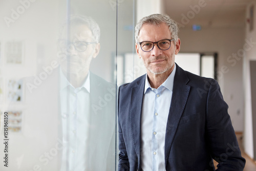 Businessman in glasses and suit standing in an office