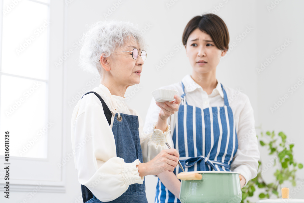 Obraz premium キッチンに立つ若い女性とシニア女性 料理イメージ