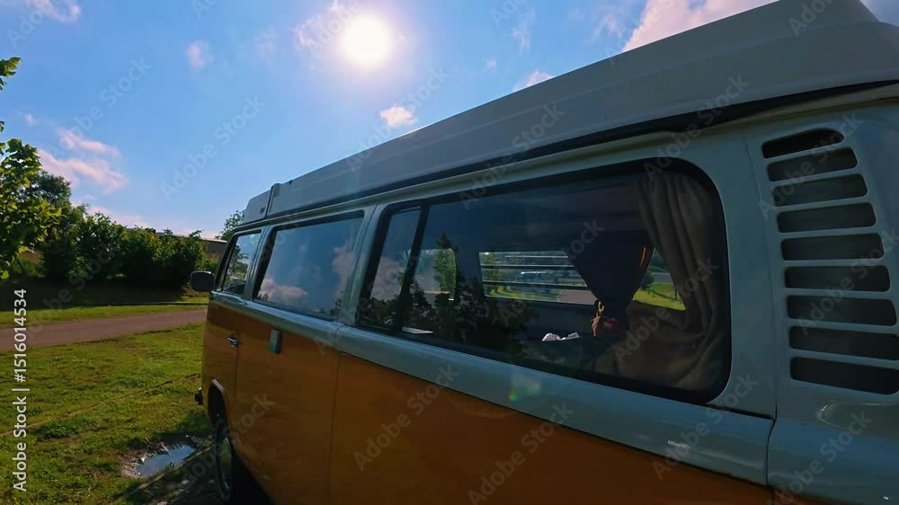 un Van jaune et blanc garé en plan rapproché de la carrosserie au halo lumineux