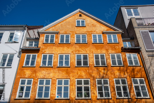 Bold red and yellow buildings in Copenhagen city center, geometric patterns, windows and details in vibrant Scandinavian architecture. photo