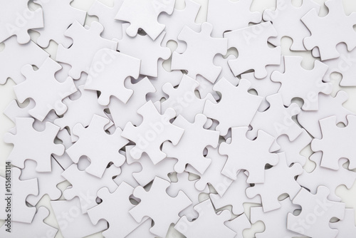 Different many white puzzle pieces background. Closeup. Top down view. photo