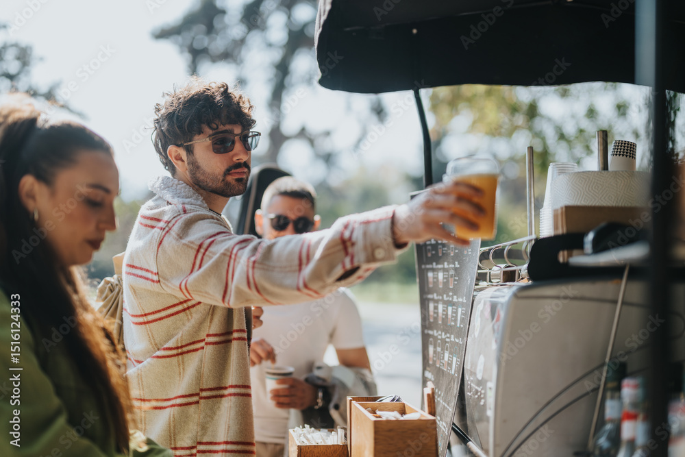 Obraz premium A group of friends enjoying drinks at a coffee stand in a sunny outdoor setting, showcasing relaxation and socializing in a vibrant atmosphere.