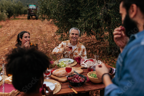 Farmers enjoying lunch together in olive grove after harvest