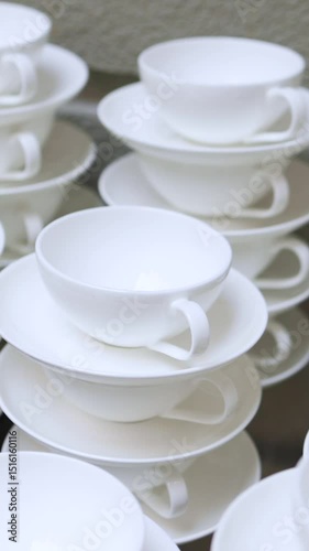 Set of coffee break lunch in the hotel restaurant during conference meeting, with tea and coffee catering, decorated banquet table with white cups, tableware and metal tea maker machine boiler
