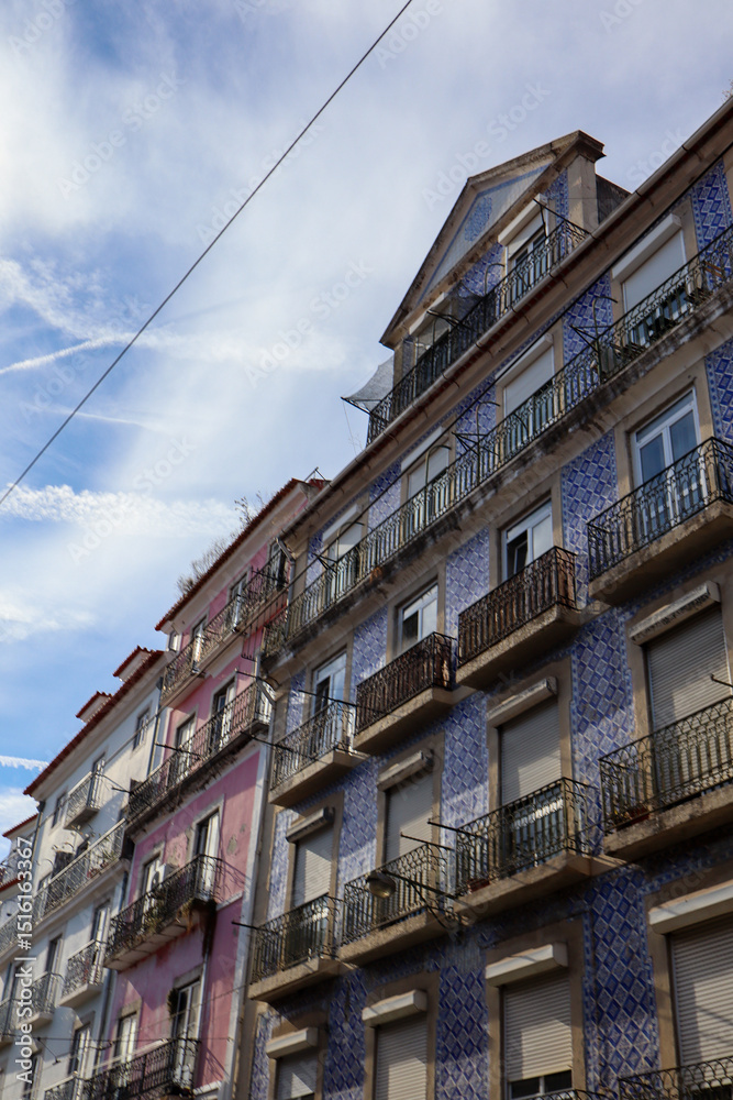 Obraz premium Charming Lisbon streets lined with colourful buildings, tiled facades, and steep hills create a vibrant, sunlit cityscape filled with culture, colour, and historic charm.