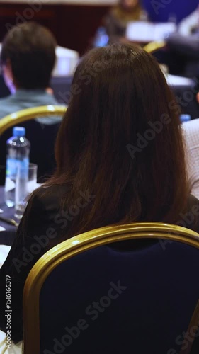 Female audience at the symposyum meeting, participants attendees in conference room hall listens to lecturer, group of women on a medical congress together listen to speaker on a stage at master-class