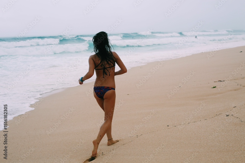 Fototapeta premium Woman running on the beach in a bikini