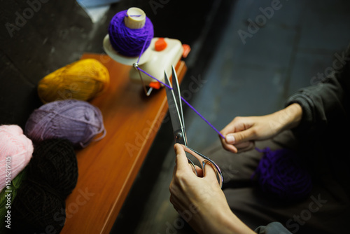Cropped shot of craftswoman cutting thread on ball winder
