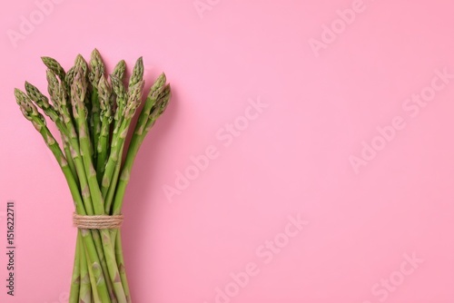 Bunch of fresh asparagus on pink background