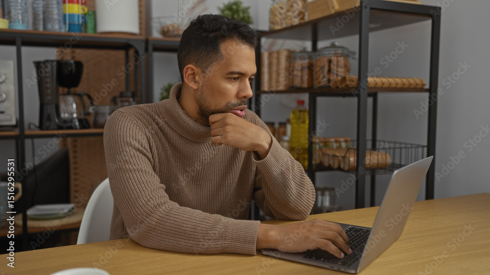 Obraz premium Young hispanic man working on laptop in modern office setting with shelves in background, portraying professional and focused atmosphere in workplace environment.