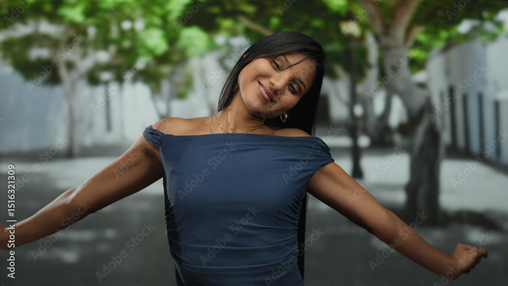 Fototapeta premium Young woman smiling joyfully in a peaceful street with trees creating a serene outdoor atmosphere, embracing a moment of happiness and tranquility.