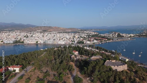 A cinematic drone reveal of Chalkida, showcasing the historic old Evripos bridge and the vibrant coastal cityscape along the Euboean Gulf. photo