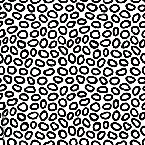 Irregular animalistic seamless pattern with hand drawn pencil textured ring shapes. Fun background with sketchy scribble spots in black and white colors. To use, drag into swatches panel