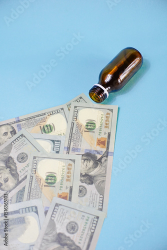 A prescription pill bottle with rolls of cash in it. Concept or metaphor for cost of drugs.