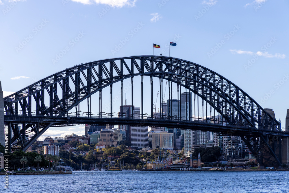 Naklejka premium Sydney Harbour Bridge spanning across the bay with city skyline in background