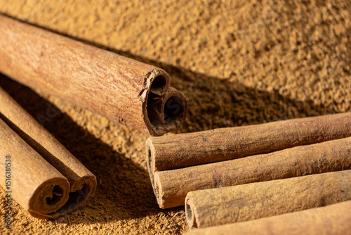 Fototapeta Naklejka Na Ścianę i Meble -  Fine Ground Cinnamon with Cinnamon Sticks. Natural Cooking Spice