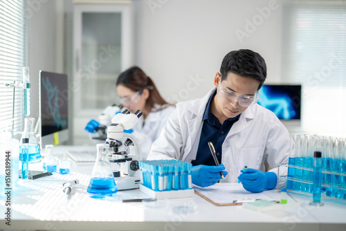 Canvastavla A man in a lab coat is writing on a clipboard