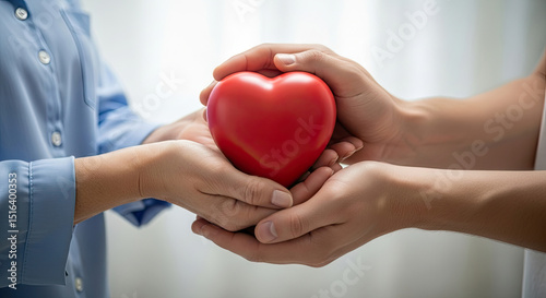 Gentle hands sharing a vibrant red heart symbolizing love care and compassion