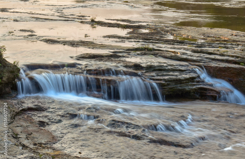 Scenic river flowing over rocky terrain, with small waterfalls, perfect for nature and landscapes in Meghalaya.