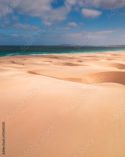Sweeping sand dunes meet the turquoise waters of the Atlantic Ocean on Boa Vista Island, Cape Verde – a stunning fusion of desert and sea in a tropical paradise
