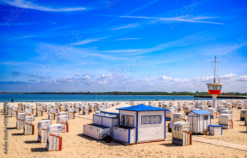 Fototapeta Naklejka Na Ścianę i Meble -  Beachside cabins lined on a sunny day showcasing vibrant colors and clear skies in a coastal location