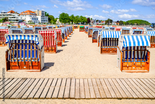 Fototapeta Naklejka Na Ścianę i Meble -  Beachside cabins lined on a sunny day showcasing vibrant colors and clear skies in a coastal location