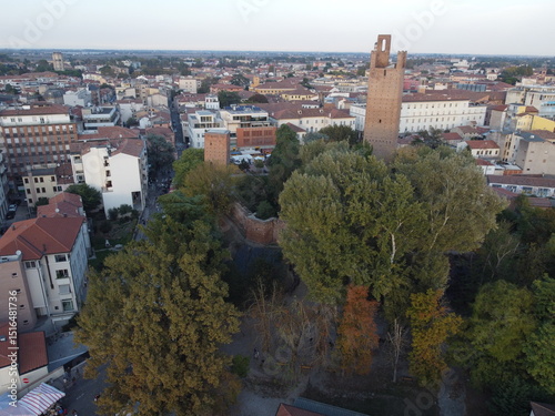 Aerial drone view of Rovigo city center, Veneto, showcasing the medieval Donà Tower, ancient castle ruins, and a mix of historic and modern buildings.