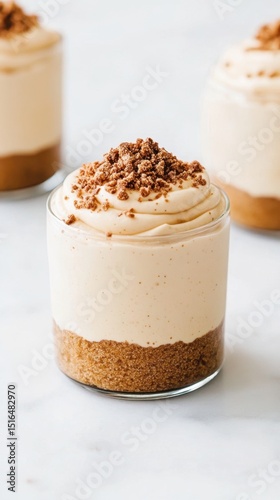 Creamy desserts in glass cups with graham cracker crust and chocolate crumble topping. Delicious food presentation with vegetarian dessert options