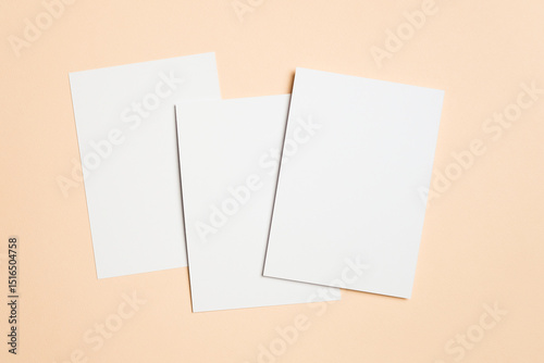 Three blank white cards on soft beige background, ideal for greeting, invitation or flyer designs presentation, wedding cards, or minimalist stationery