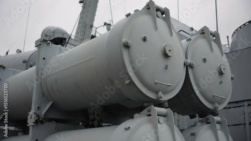 Grey Torpedo Launchers are installed on a Military Warship with overcast sky The warship's missile system illustrates naval technology and industrial design on a naval vessel