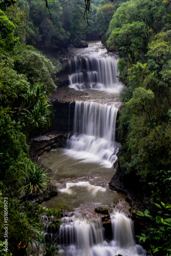 Wei sawdong , a multitiered waterfall cascading down rocky cliffs, surrounded by lush green foliage. A beautiful waterfall in Meghalaya.
